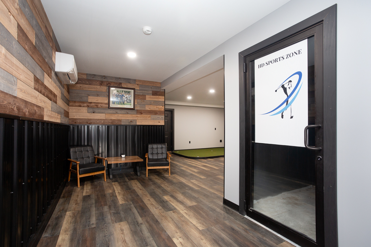 Lounge seating beside the HD SPORTS ZONE branded glass entrance door