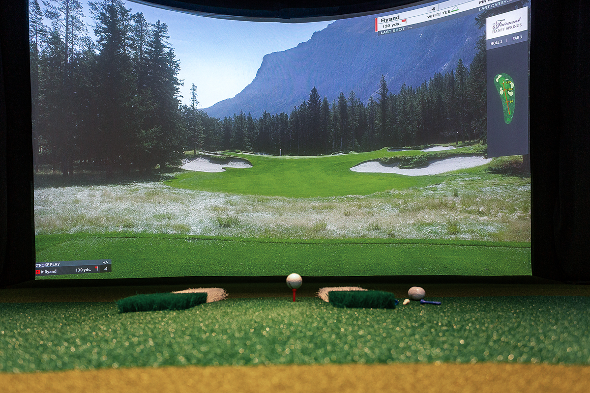 Hitting mat and tee facing Fairmont Banff Springs on the simulator screen